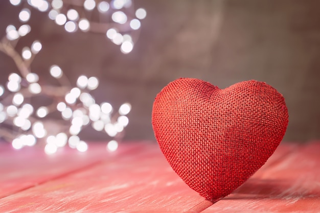 Valentines day background with red heart over red wooden table