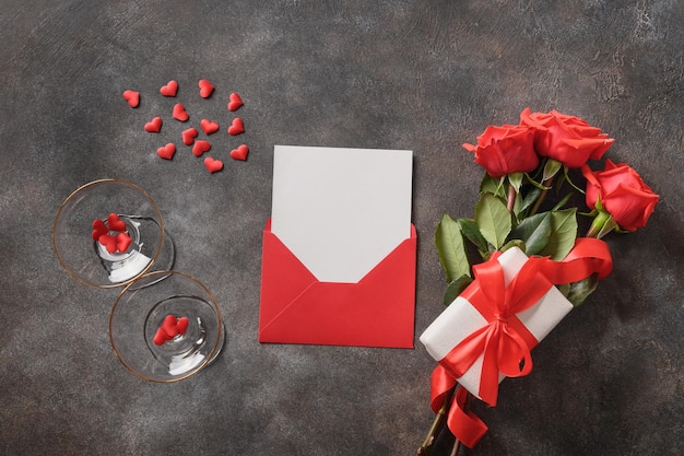 Valentines day card with love letter in envelope red roses and wine glasses for champagne