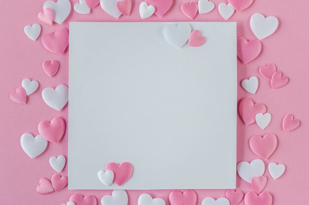 Valentines day concept. Greeting card with a pink and white hearts and space for text on a pink background. Top view. Flat lay. Close up.