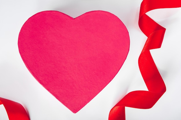 Valentines day concept Red silk ribbon and heart on a white background