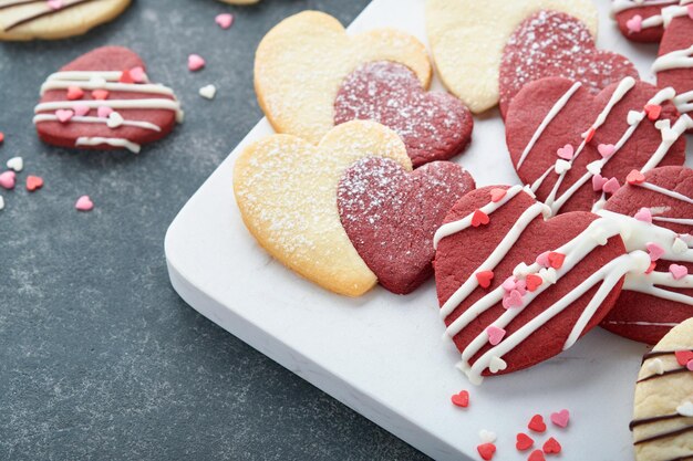 Valentines day cookies Shortbread cookies inside sweet red heart with chocolate glaze on pink plate on grey background Mothers day Womans day Sweet holidays baking Valentines day card Top view