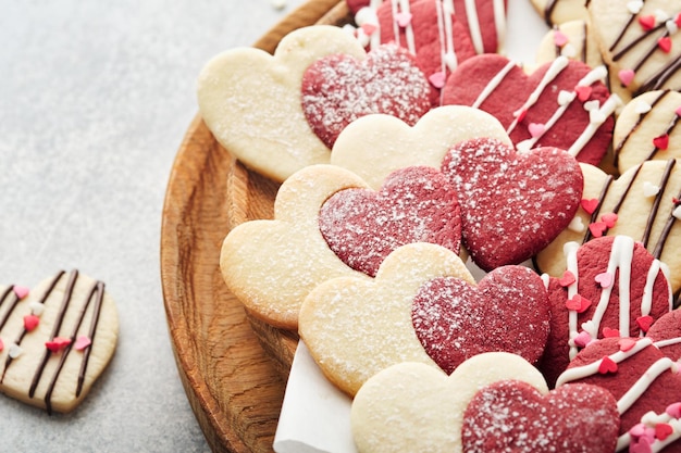 Valentines day cookies Shortbread cookies inside sweet red heart with chocolate glaze on pink plate on grey background Mothers day Womans day Sweet holidays baking Valentines day card Top view