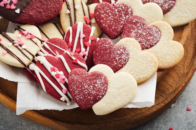 Valentines day cookies Shortbread cookies inside sweet red heart with chocolate glaze on pink plate on grey background Mothers day Womans day Sweet holidays baking Valentines day card Top view