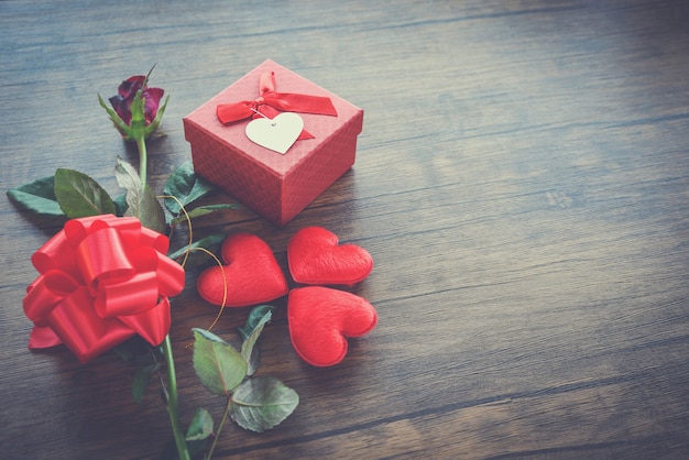 Valentines day gift box red on wood Red Heart Valentines day red rose flower and present box ribbon bow on old wooden