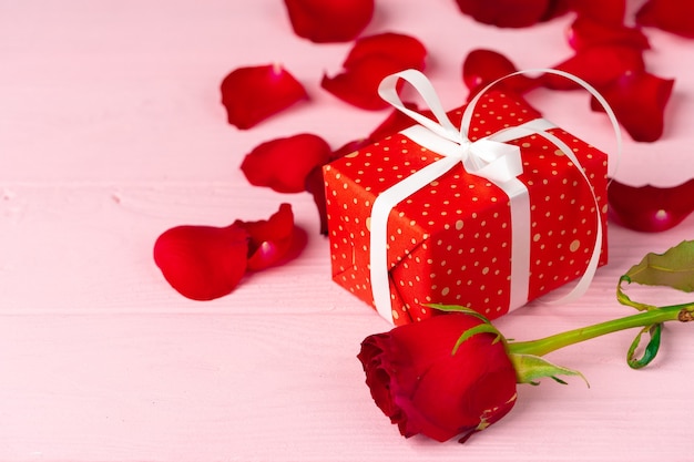 Valentines day gift and rose on wooden table close up