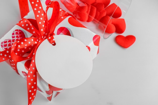 Valentines day gift with round white gift tag mockup on marble background with red heart sale and