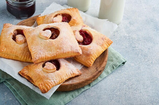 Valentines day heart shaped Hand pies Mini puff pastry or hand pies stuffed with apple and sprinkle sugar powder in plate Idea for homemade romantic snack Valentines day Top view Copy space