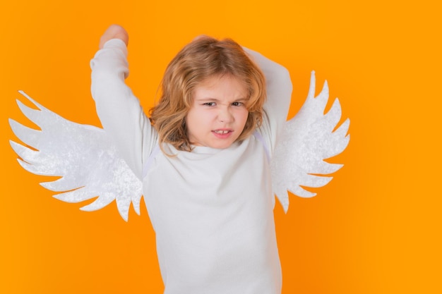 Photo valentines day kid with angel wings studio portrait of angel child on studio color isolated background with copy space