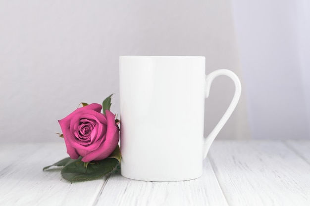 Valentines day mug, cup on the wooden table and white background with red rose.