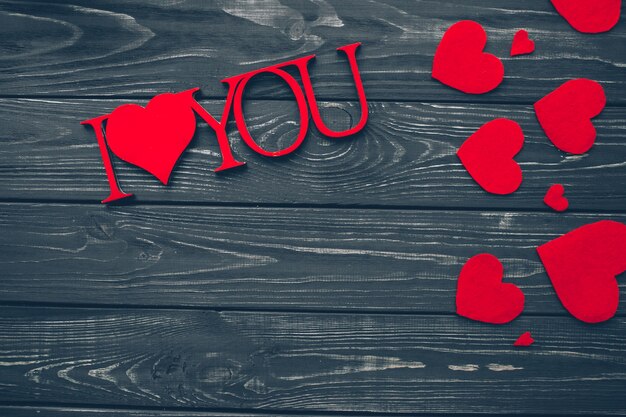 Photo valentines day, red hearts on wooden background