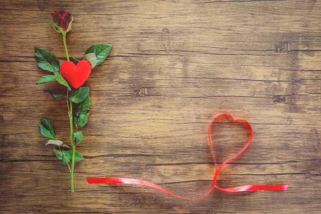 Valentines day red rose flower on wooden Red heart with roses and red ribbon heart on top view copy space 