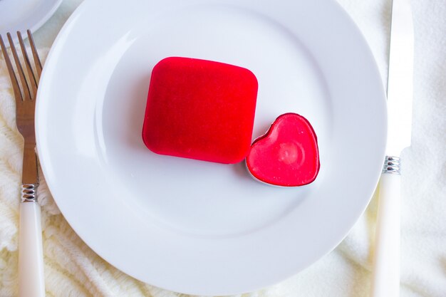 Valentines day tablesetting with red velvet ring box, candle and silverware