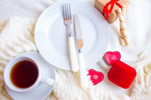 Valentines day tablesetting with red velvet ring box, candles and silverware