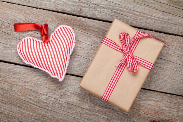 Valentines day toy heart and gift box over wooden table background