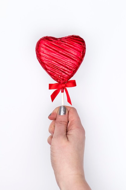 Valentines's day gift Female hand holding a heart shaped lolly