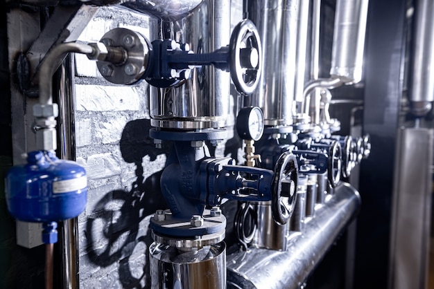 The valves and pipes at a craft modern brewery wall