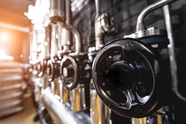 The valves and pipes at a craft modern brewery wall