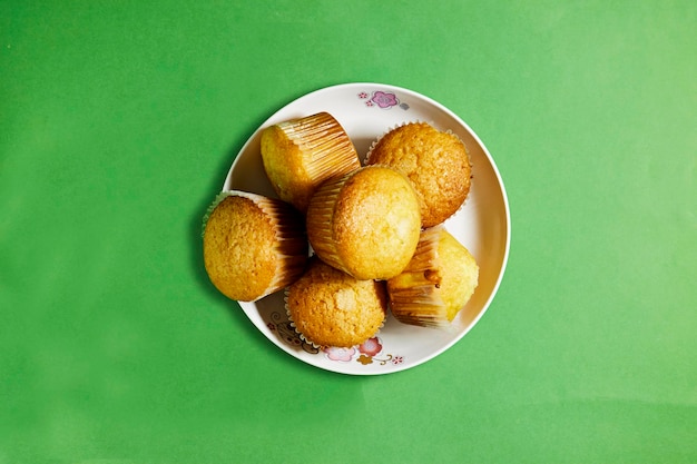 Vanilla Caramel Nuts Muffins In Paper Cups in plate on green background