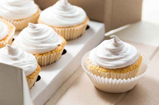 Vanilla cupcakes with white cream in delivery box