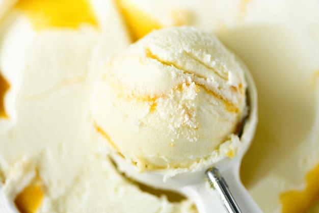 Vanilla ice cream scoop . Summer food concept. Scooped texture. Scooping out yellow mango ice-cream.