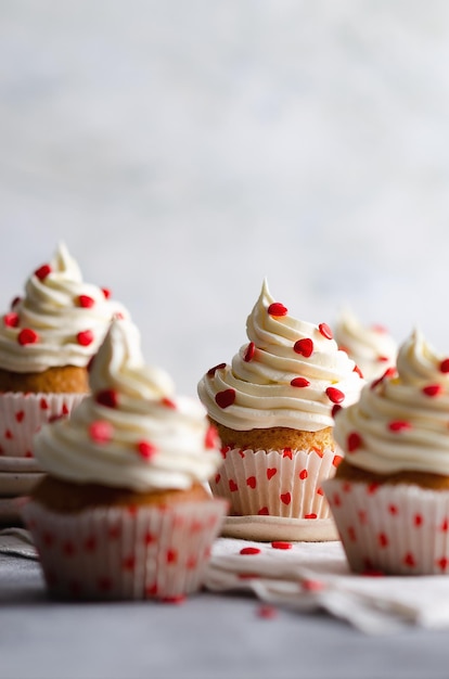 Vanilla muffins on plates and a white cloth on a grey background