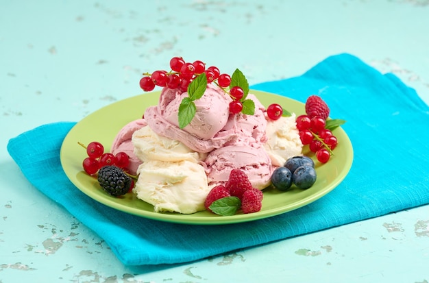 Vanilla and raspberry ice cream scoops on a round green plate