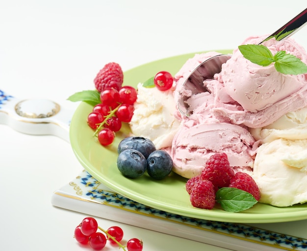 Vanilla and raspberry ice cream scoops on a round green plate