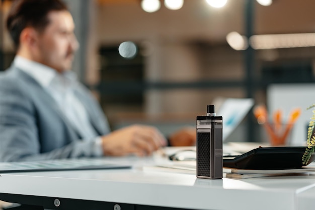 Vape on the working table of a male businessman