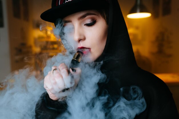 Vaping girl young hipster woman vape ecig at the vapeshop hiphop style closeup