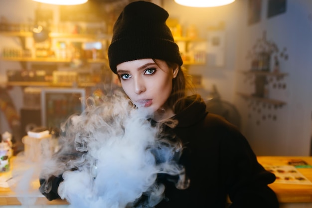 Vaping girl young hipster woman vape ecig at the vapeshop hiphop style closeup