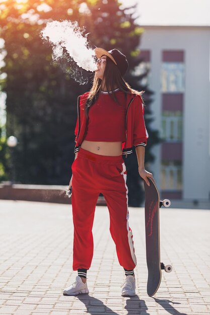 Vaping girl young woman with skateboard vape ecig