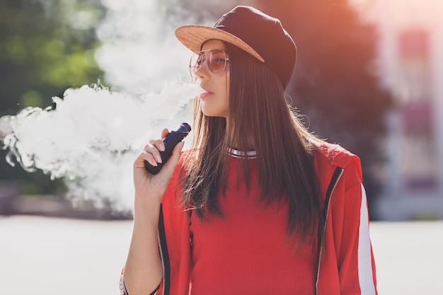 Vaping girl young woman with skateboard vape ecig