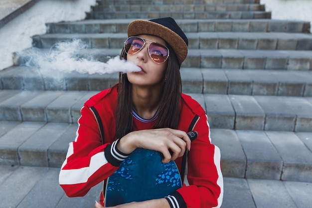 Vaping girl young woman with skateboard vape ecig