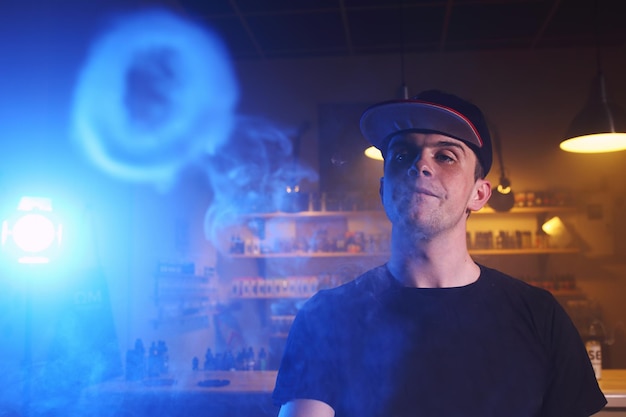 Vaping man in a cloud of vapor in a vape bar