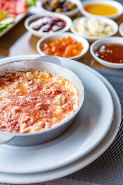 Varied breakfast, set of scrambled eggs with tomatoes and classic scrambled eggs, different types of snacks