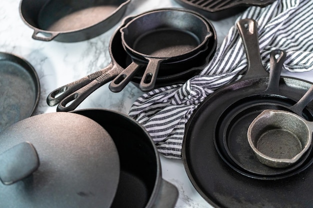 Variety of cast iron frying pans on a marble background.