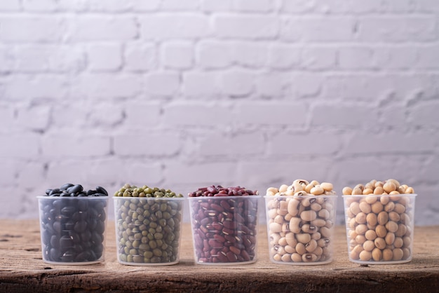 Variety of dried beans on wood table.