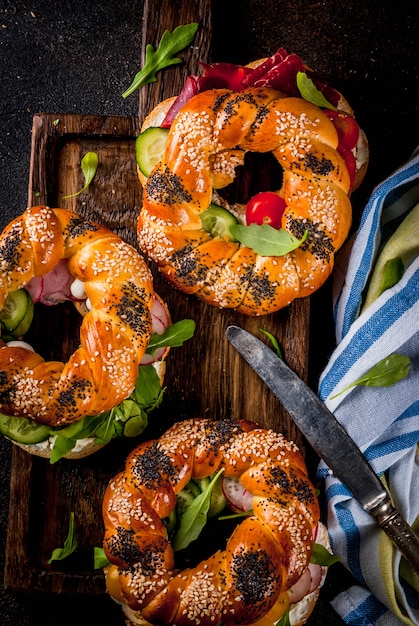 Variety of homemade bagels sandwiches with meat and vegetables