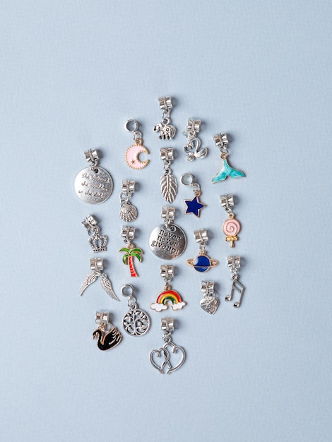 A variety of metal charms for a child's necklace or bracelet Many charms isolated on a white background planet star seashell tree crown lekki etc