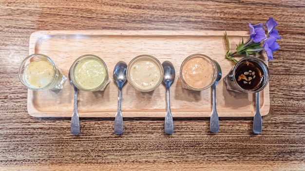 Variety of salad dressing on the wooden table