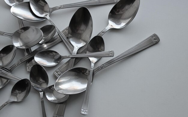 Variety Size Silvery Spoons On Clean White Surface Concept Photo For Table Setting Illustration