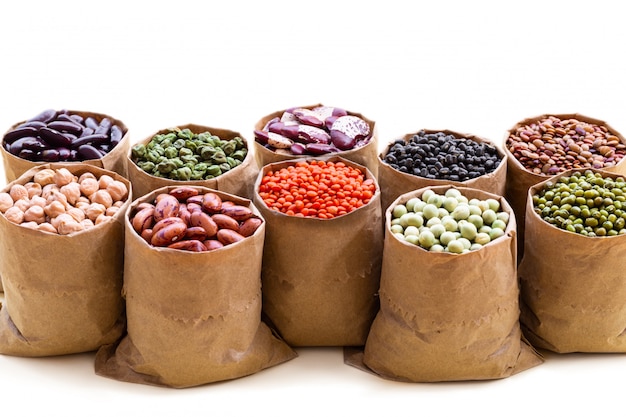 Various assortment set of indian legumes in paper sack bags isolated on white background.