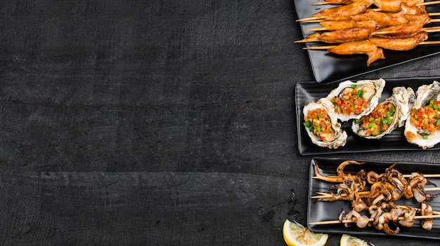 Various barbecue delicacies are placed on the black wood background