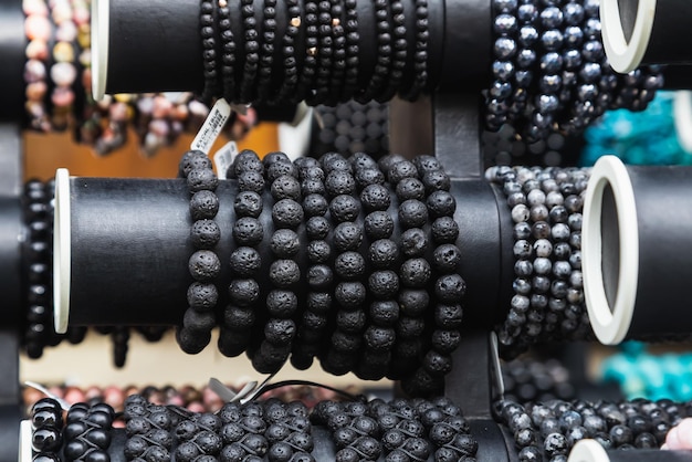 Various black beautiful gem bracelets stacked together for sale in the market