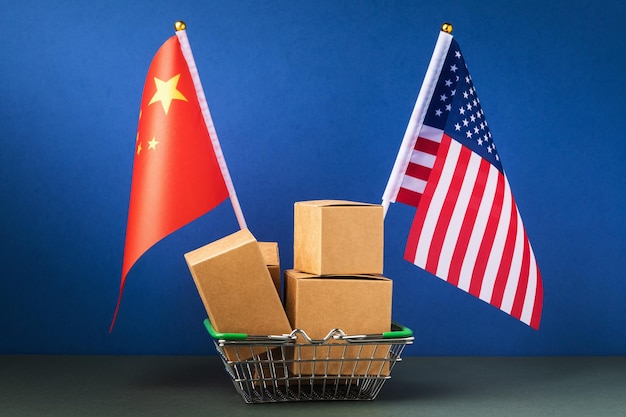 Various boxes in a food basket and two flags on a blue background, the concept of trade between China and the United States of America