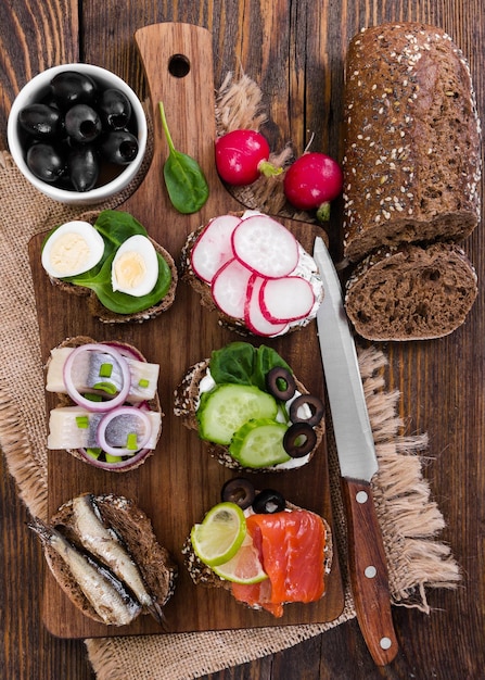 Various bruschettas on board on wooden background Top view