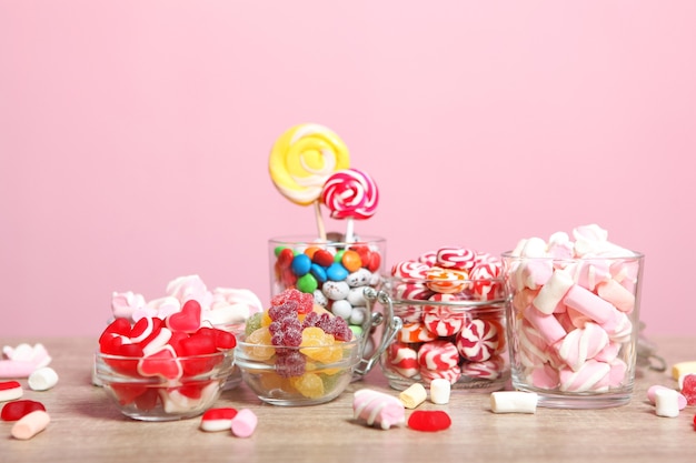 Various candy and sweets on the table on a colored background