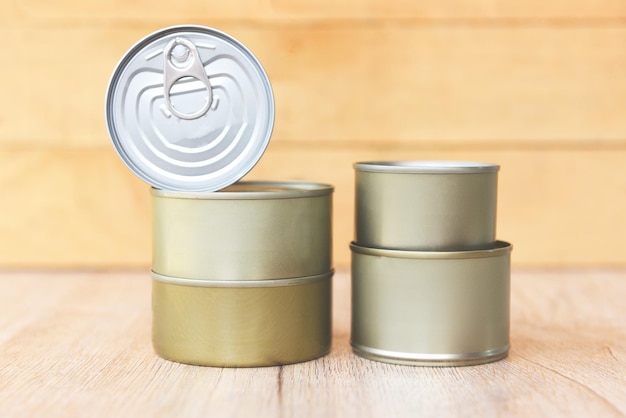 Photo various canned food in metal cans on wooden background canned goods non perishable food storage goods in kitchen home or for donations