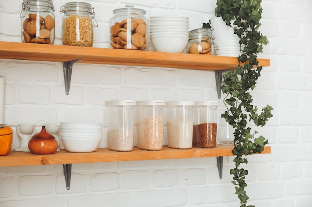 Various cereals in glass jars placed on wooden shelves in the kitchen pasta and cereals