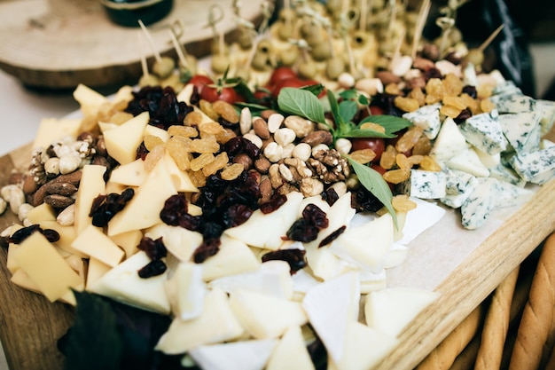 Various cheeses dried fruits and nuts on the wedding table Cold snacks for guests in the restaurant